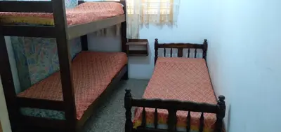 two bunk beds are in a room with a wall at Dptos LOW COST in Mina Clavero