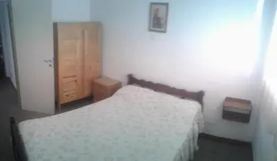 a bedroom with two beds and a wooden cabinet at Dptos LOW COST in Mina Clavero
