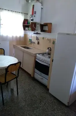 a kitchen with a stove and a sink and a refrigerator at Dptos LOW COST in Mina Clavero