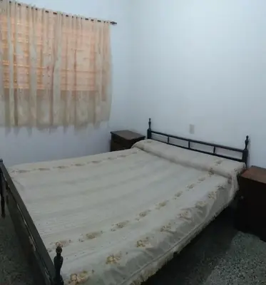 a bed in a room with a window at Dptos LOW COST in Mina Clavero