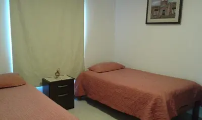a room with two beds and a night stand with two beds at Tu Casa en Villa General Belgrano Calamuchita Córdoba in Villa General Belgrano