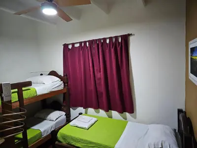 a bedroom with two bunk beds and a red curtain at Mi casa, equipada para el viajero y su familia in Cordoba