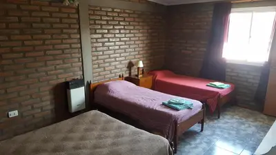 a room with two beds and a brick wall at Santa isabel in Embalse