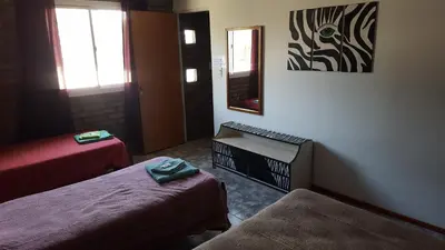 a small room with two beds and a mirror at Santa isabel in Embalse