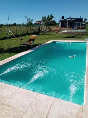 a swimming pool in a yard with a chair at El Reencuentro in Los Reartes