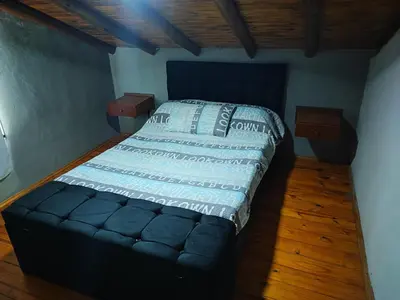 a bedroom with a bed with a blue comforter at El Reencuentro in Los Reartes