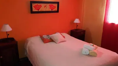 a bedroom with a white bed with orange walls at El Reencuentro in Los Reartes