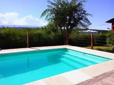 a swimming pool with blue water in front of a fence at El Reencuentro in Los Reartes
