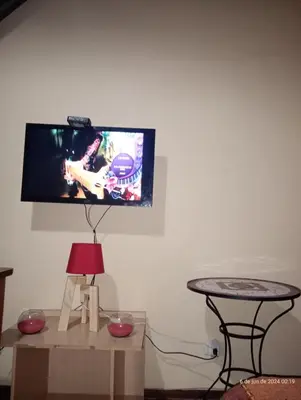 a living room with a tv on the wall at El Reencuentro in Los Reartes