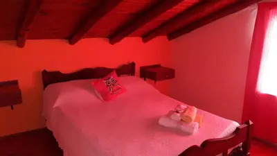 a red bedroom with a bed with a teddy bear on it at El Reencuentro in Los Reartes