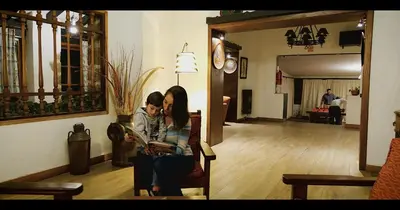 a man and a woman sitting in a chair in a living room at Los Espinillos Hotel y Spa in Villa Carlos Paz