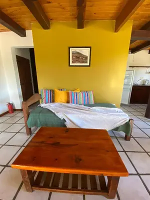 a bedroom with a bed and a wooden table at Cabañas Los Maderos in Villa General Belgrano