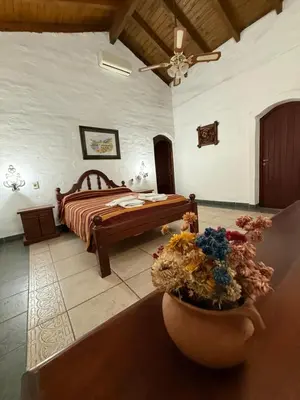 a bedroom with a bed and a vase of flowers at La Posta del Mistol in Las Tapias