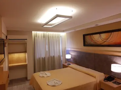 a hotel room with a bed and a window at Hotel Presidente in Villa Carlos Paz