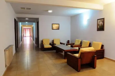 a waiting room with chairs and a table and a hallway at Hotel Presidente in Villa Carlos Paz