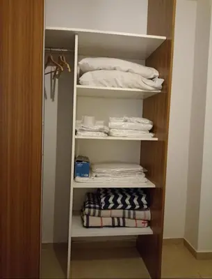 a closet with white shelves and folded towels at Apartamentos Santa Rosa PB 2 in Cordoba
