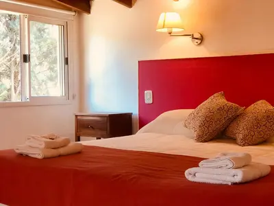a bedroom with a bed with towels on it at Posada del Tiempo in Merlo