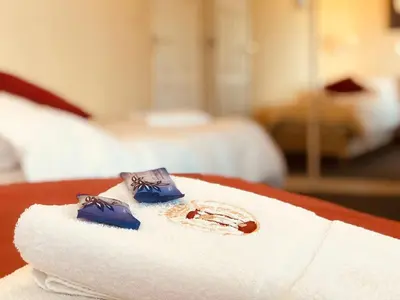 a pile of towels on a table in a hotel room at Posada del Tiempo in Merlo