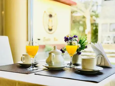 a table with two glasses of orange juice and flowers at Posada del Tiempo in Merlo