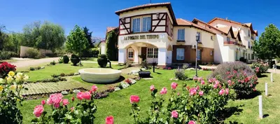 a house with a garden with pink flowers at Posada del Tiempo in Merlo