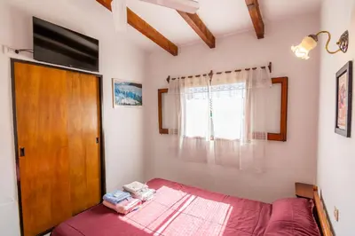 a bedroom with a bed and a wooden door at HOSTERIA NIDO DE CONDORES-Solo Adultos in Mina Clavero