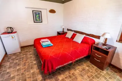 a bedroom with a red bed with a red blanket at HOSTERIA NIDO DE CONDORES-Solo Adultos in Mina Clavero