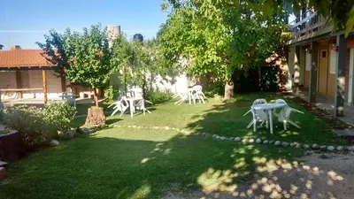 a yard with white tables and chairs on the grass at HOSTERIA NIDO DE CONDORES-Solo Adultos in Mina Clavero