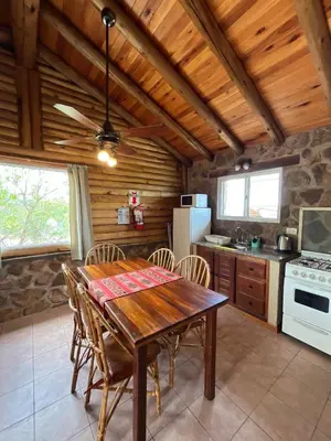 a dining room with a wooden table and chairs at Al Encuentro Casas de Montaña in Nono