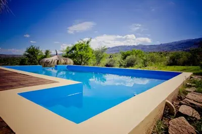 a large blue swimming pool with a view at Al Encuentro Casas de Montaña in Nono