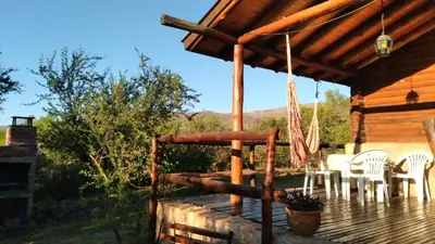 a porch of a cabin with chairs and a hammock at Al Encuentro Casas de Montaña in Nono