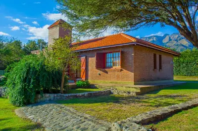a small brick house with a chimney on a yard at Complejo Vip Houses in Merlo