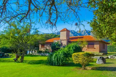 a house with an orange roof in a green yard at Complejo Vip Houses in Merlo