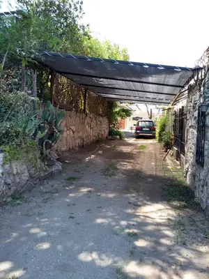 a garage with a black cover over a dirt road at La Caballeriza habitación doble in Alta Gracia