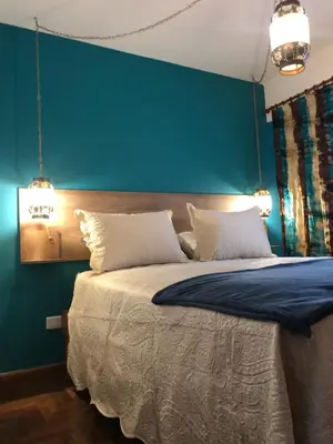 a bedroom with a large bed with a green wall at apart Italia in Río Cuarto