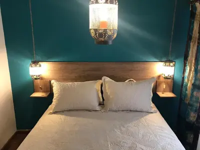 a bedroom with a bed with two pillows and two lights at apart Italia in Río Cuarto