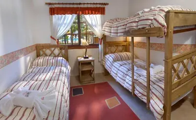 a bedroom with two bunk beds and a window at Cabañas Los Duendes in Villa General Belgrano