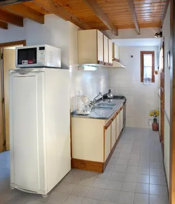 a kitchen with a sink and a microwave at Cabañas Los Duendes in Villa General Belgrano