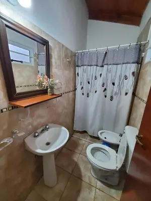 a bathroom with a toilet and a sink at Cabañas Rosaditas in Santa Rosa de Calamuchita