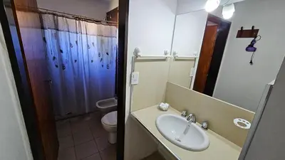 a bathroom with a sink and a toilet and a mirror at Cabañas Rosaditas in Santa Rosa de Calamuchita