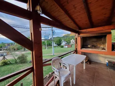 a view from the porch of a tiny house with a table and chairs at Cabañas Rosaditas in Santa Rosa de Calamuchita