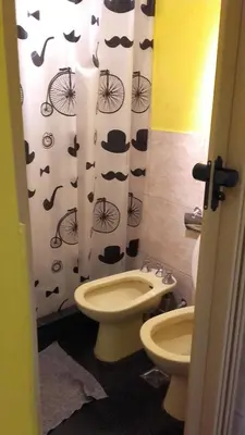 a bathroom with a toilet and a shower curtain with hats at Santorini Bed en Córdoba in Cordoba