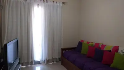 a living room with a purple couch and a window at alto villa sol in Cordoba