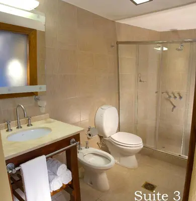 a bathroom with a toilet and a sink and a shower at Suites de la Colina in La Cumbrecita