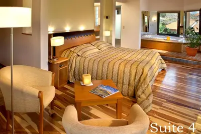 a bedroom with a bed and a table and chairs at Suites de la Colina in La Cumbrecita