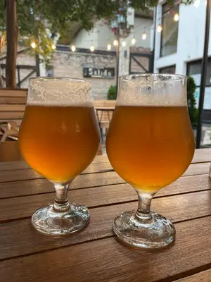 two glasses of beer sitting on a wooden table at Hotel Samay Huasi in Villa General Belgrano