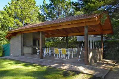 a pavilion with chairs and a table in a yard at Hotel Samay Huasi in Villa General Belgrano