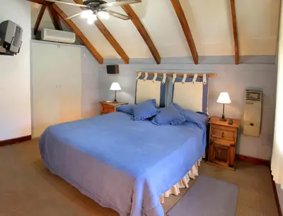 a bedroom with a blue bed with blue pillows at Cabañas y Lofts El Portal in Villa General Belgrano