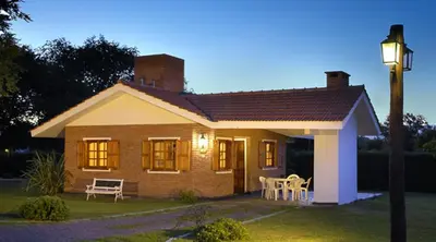 a small house with a table and chairs in the yard at Cabañas y Lofts El Portal in Villa General Belgrano