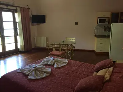 a bedroom with a large bed with towels on it at Cabañas y Lofts El Portal in Villa General Belgrano