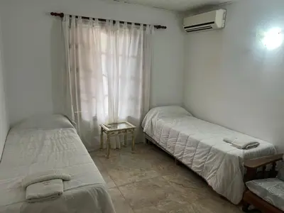 two twin beds in a room with a window at Cabañas y Lofts El Portal in Villa General Belgrano